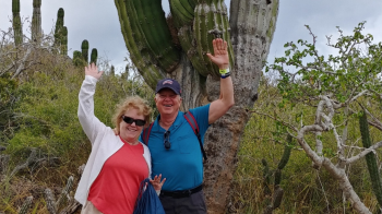 Barbara and her husband infront of a cactus